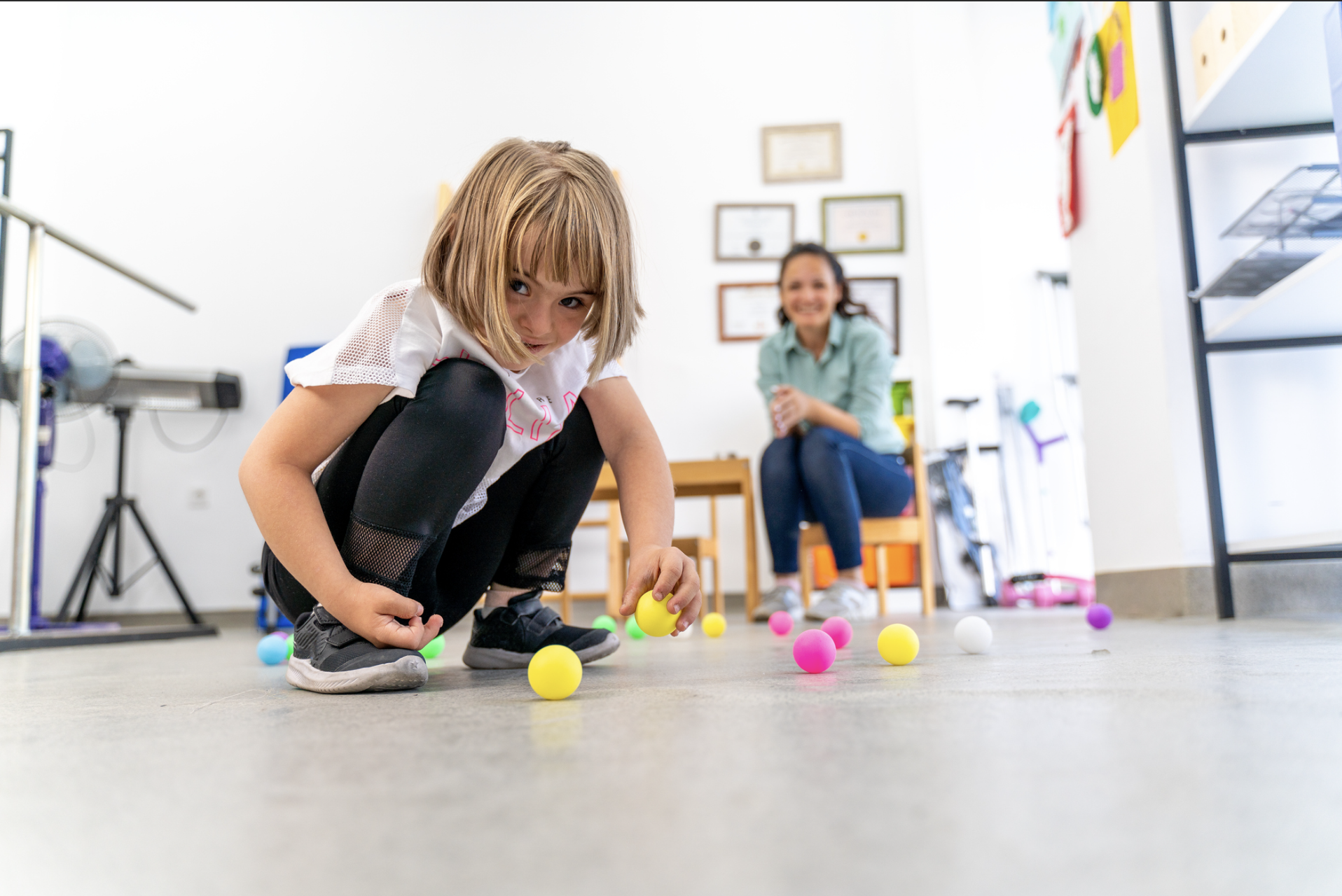 Young girl engaged in occupational therapy, playing with colorful toys to improve fine motor skills